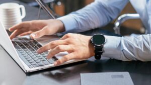 Gehschäftsmann sitzt am Laptop und recherchiert nach Informationen zu gebrauchten Lizenzen.