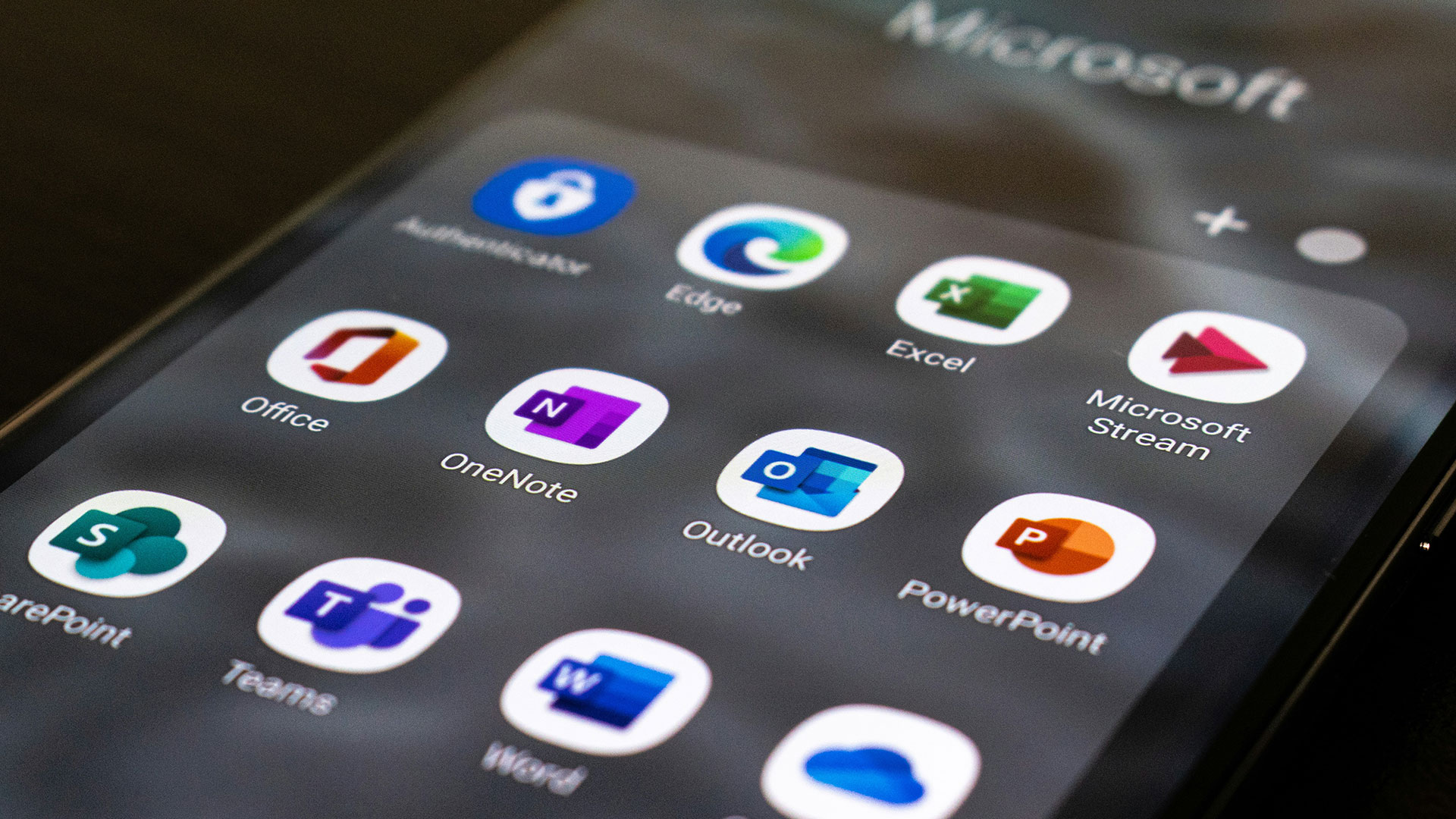 Eine fotografiertes Smartphone-Bildschirm auf dem Apps von Microsoft 365 angezeigt werden.