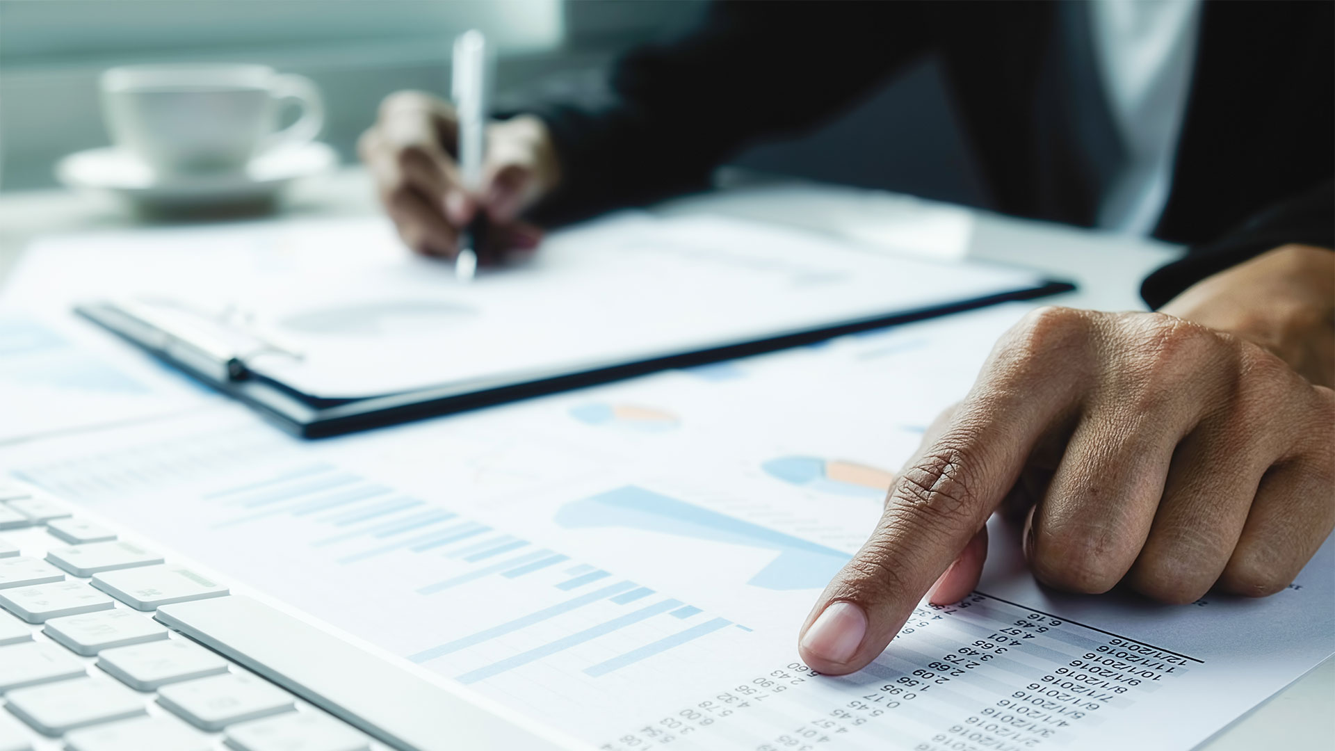 Mann sitzt am Schreibtisch. Und kalkuliert die Kosten für bestehende Software Lizenzen durch.